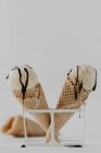 Cones de sorvete com sorvete de baunilha e molho de chocolate pingando — Fotografia de Stock
