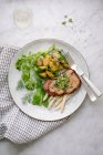 Veal escalope on bed of mini asparagus and wild cabbage salad — Stock Photo