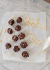 Cappuccino pralines on paper decorated with the words 'Frohes Fest' — Stock Photo