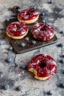 Donuts com esmalte de mirtilo e glitter em pó — Fotografia de Stock