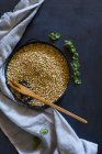 Quinoa vert cru dans un bol sur un fond sombre. vue de dessus. — Photo de stock