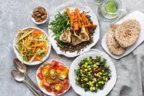 Various vegetable salads with pita bread — Stock Photo