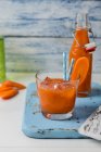 Морквяний сік у склянці на дереві — стокове фото