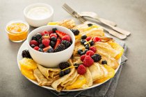 Тонкие блины со свежими фруктами и ягодами, подаваемые с мармеладом и сливочным сыром — стоковое фото