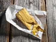 Кусок альпийского сыра на выветриваемой деревянной доске — стоковое фото