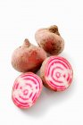 Chioggia beets, whole and halved against a white background — Stock Photo