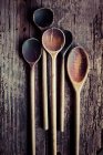 Diversi vecchi cucchiai di legno su uno sfondo di legno — Foto stock