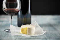 Soft cheese and red wine glass and bottle — Stock Photo