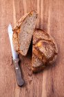 Половина картопляного хліба з ножем на дерев'яній поверхні — стокове фото
