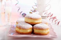 Doughnuts for carnival with streamers and a glass of champagne — Stock Photo