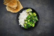 Curry tailandese verde con broccoli, pak choy, mange tout, spinaci baby, lime e riso — Foto stock