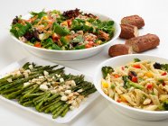 Grüner Spargel, Penne mit Gemüse und gemischtem Salat, dazu Brot — Stockfoto