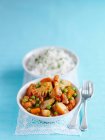Curry de coliflor con guisantes, zanahorias, patatas y arroz - foto de stock