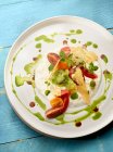 Буррата с красными и зелеными помидорами, бальзамическим и базиликовым маслом — стоковое фото