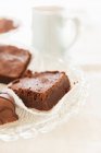 Brownies y confitería de chocolate en un plato de vidrio - foto de stock