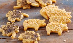 Spicy biscuits shaped like clover leaves and pigs with poppy seeds and sesame seeds — Stock Photo