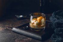 Helado con cobertura de caramelo y licor de crema irlandesa en un vaso sobre fondo oscuro - foto de stock