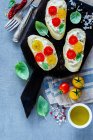 Крупный план домашнего томата и брускетты базилика или сэндвичей с ингредиентами на светло-сером фоне — стоковое фото