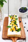 Yoghurt and coconut tart with mango, blueberries and mint — Stock Photo