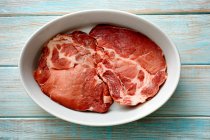 Raw pork collar steaks in a bowl — Stock Photo