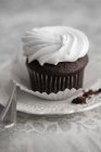 Un cupcake al cioccolato condito con crema — Foto stock