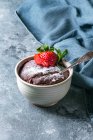 Chocolate mug cakes from microwave with strawberry and sugar powder over blue texture background — Foto stock