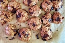 Biscuits with chocolate on baking paper, close up — Stock Photo