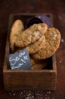 Biscuits au sel de mer et chocolat en boîte en bois — Photo de stock