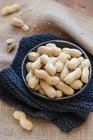Peanuts in a bowl on a wooden background — Stock Photo