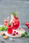 Raspberry and peach iced tea with mint and ice — Stock Photo
