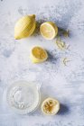 Limoni pelati e spremiagrumi, sfondo chiaro — Foto stock