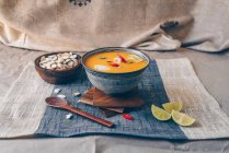 Пряний азіатський гарбузовий суп, прикрашений червоним чилі, варенням та гарбузовим насінням, увінчаний кокосовим кремом — стокове фото