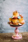 Cupcakes with eatable flowers and animal decorations — Stock Photo