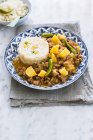 Plate with picadillo con papas garnished with green peppers and served with rice, sweet corn and peas — Stock Photo