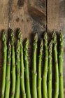 Green asparagus spears on a wooden background (top view) — Stock Photo