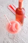 A slushy FRO's in a cocktail glass with a bottle of rose wine — Stock Photo
