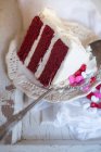 Um pedaço de bolo de veludo vermelho e gotas de coração — Fotografia de Stock