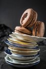 Три шоколадных макарона на пачке тарелок — стоковое фото