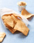 Pita chips con hummus su superficie blu — Foto stock