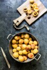Abricots frais en passoire métallique et sur planche de bois — Photo de stock
