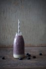 Веганский орех кешью и черничный смузи в стеклянной бутылке — стоковое фото