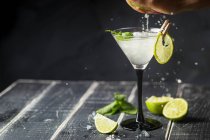Hand drückt Limette in Glas Margarita-Cocktail — Stockfoto