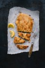 Classic Viennese veal escalope on grease-proof paper, sliced — Stock Photo