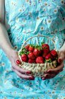 Cropped shot of woman holding basket of fresh strawberries — Stock Photo