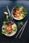 Udon noodle soup with Katsu escalope, chard, egg, fried mushrooms, coriander, lime and onion shoots — Stock Photo