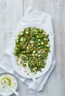 Mixed Green Meze mit Zucchini Gartenerbsen Spargel gemischt frischen Kräutern und garniert mit zerbröckeltem Ziegenkäse — Stockfoto