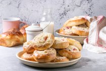 Traditional cottage cheese and srtawberry buns Moravsky colac in ceramic plate standing with bottle of milk on grey kitchen table — Stock Photo