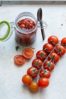 Tomato sauce in a glass and fresh cherry tomatoes — Stock Photo