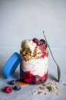 Йогурт з мюслі та фруктовим компотом у скляній банці — стокове фото