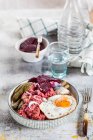 Lobscouse con aringhe saltate, uova fritte, barbabietole e cetriolini — Foto stock